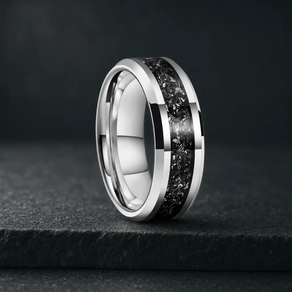 The Ascent, an 8mm polished titanium band in silver and black with a meteorite inlay, standing upright on a dark iron grey stone slab