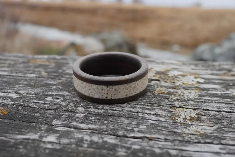 An antler inlay band on weathered wood outdoors