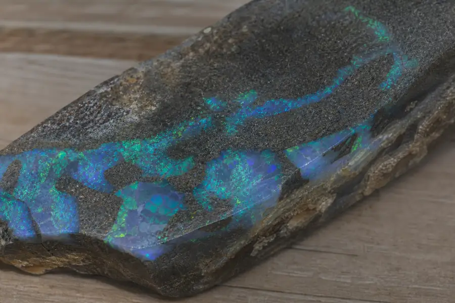 Black opal inlay flashing blue and green under directional light
