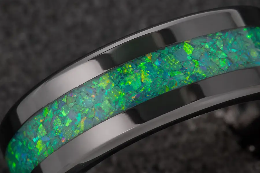 Macro of green opal inlay flashing colour against black tungsten